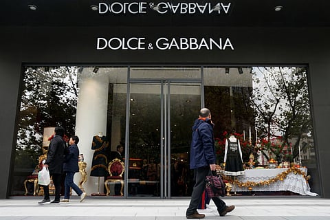People walk past a Dolce & Gabbana store at a shopping complex in Shanghai. The Milan fashion house has filed a multimillion-dollar defamation suit in an Italian court against US fashion bloggers who reposted anti-Asian comments attributed to one of the designers.