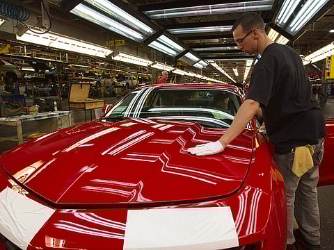 File photo: A worker checks the paint on a Camaro at the GM factory in Oshawa, Ontario.