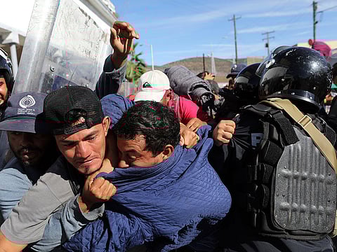 Migrants clash with Mexican police at the Mexico-U.S. border after getting past another line of Mexican police at the Chaparral crossing in Tijuana, Mexico, Sunday, November 25, 2018, as they try to reach the US.