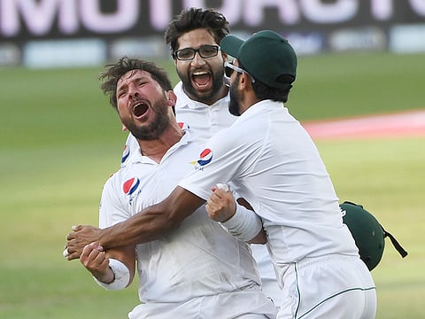 Pakistan's bowler Yasir Shah (L) reacts with Imam-ul-Haq (C) and Hasan Ali after the victory in the test match against New Zealand in Dubai.
