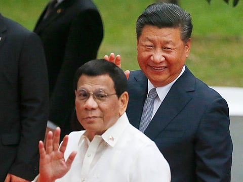 In this Tuesday, Nov. 20, 2018, file photo, Chinese President Xi Jinping, right, and Philippine President Rodrigo Duterte wave to the media following a welcome ceremony at Malacanang Palace in Manila, Philippines.