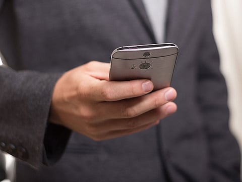 A man holding a smartphone. For illustrative purposes only