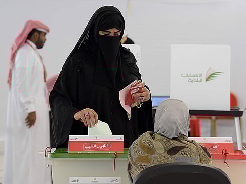 A voter casts her ballot in the parliamentary and municipal elections at the University of Bahrain polling center.