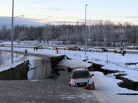 A car is trapped on a collapsed section of the offramp of Minnesota Drive in Anchorage, Friday, Nov. 30, 2018.