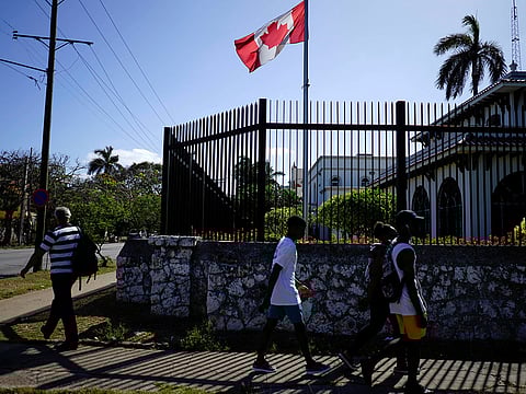 People pass by the Canada's Embassy in Havana, Cuba, April 16, 2018.