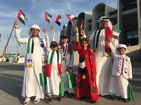Emirati Ali Al Alavi and his children wave the national flags during the celebrations.