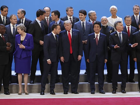 US President Donald Trump, front center, listens to France's President Emmanuel Macron as they pose with world leaders for a group picture at the start of the G20 Leader's Summit inside the Costa Salguero Center in Buenos Aires, Argentina.