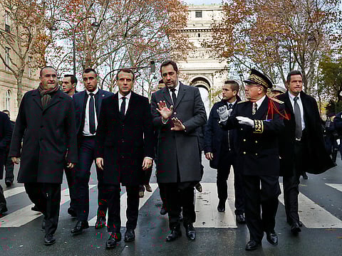 France's President Emmanuel Macron, centre left, Interior Minister Christophe Castaner, centre, Secretary of State to the Interior Minister Laurent Nunez, left, and police Prefect Michel Delpuech, right, arrive to visit firefighters and riot police officers the day after a demonstration, in Paris, Sunday, Dec. 2, 2018.