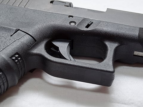 A close up of a black semi automatic pistol. For illustrative purposes only.