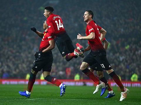 Manchester United's midfielder Jesse Lingard, centre, jumps on the shoulders of teammate Anthony Martial who scored his side's first goal.
