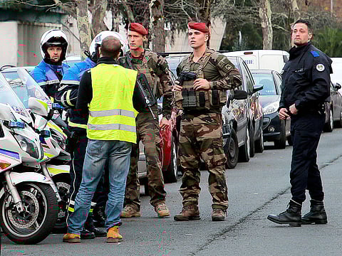 A demonstrator wearing a yellow vest talks to police officers and soldiers in Bayonne, southwestern France, Thursday, Dec.6, 2018.