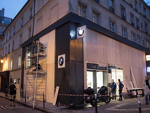 Workers set up wood panels to protect shop windows, near the Bastille Place in Paris on December 6, 2018.