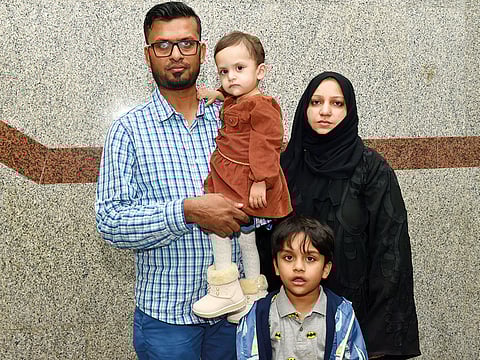 Mohammad Farooq carries 18-month-old Hajirah as his son Dawood and wife Habeeba look on. Mohammad is seeking help from residents to save his daughter.