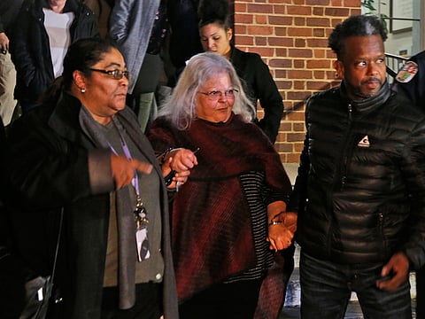 Susan Bro, center, mother of Heather Heyer, is escorted down the steps of the courthouse after a guilty verdict was reached in the trial of James Alex Fields Jr., Friday, Dec. 7, 2018, at Charlottesville General district court in Charlottesville, Va. Fields was convicted of first degree murder in the death of Heather Heyer as well as nine other counts during a "Unite the Right" rally in Charlottesville