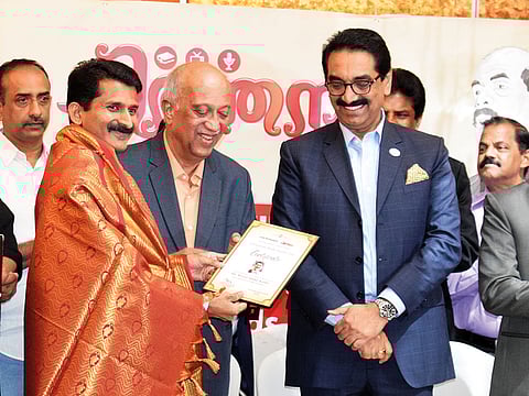 Binsal Abdul Kader (left) receives V.M. Satish Media Award for best Indian journalist in English in the Gulf region.
