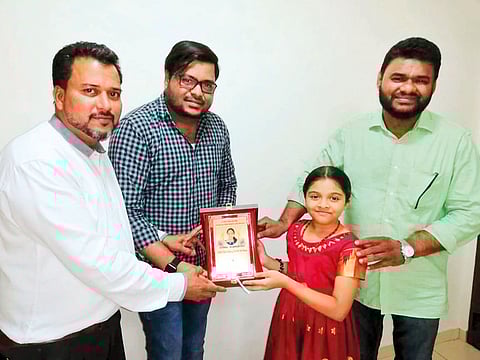 Siba Shabeer receiving a token of recognition by a community organisation. Due to her scream, the baby was lucky enough to be caught when she fell.