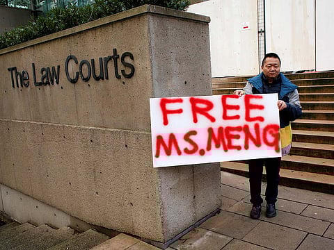 A man holds a sign outside of the B.C. Supreme Court bail hearing of Huawei CFO Meng Wanzhou, who is being held on an extradition warrant in Vancouver, British Columbia, Canada December 10, 2018.