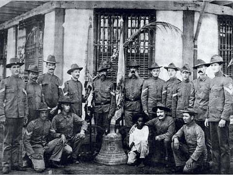 US soldiers of Company C, 9th Infantry Regiment who survived the Balangiga massacre pose with one of the Balangiga bells. Photo taken in Calbayog, Samar, in April 1902