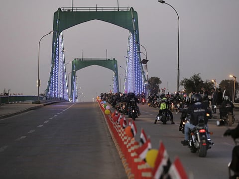 Motorists drive on a suspension bridge on their way to the Green Zone partially reopens, Baghdad, Iraq, Monday, Dec. 10, 2018. Iraq celebrated the anniversary of its costly victory over the Islamic State group, which has lost virtually all the territory it once held but still carries out sporadic attacks. (AP Photo/Karim Kadim)