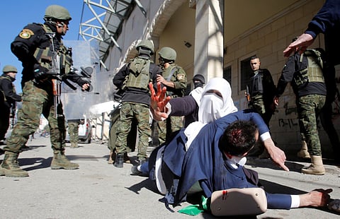 A woman reacts a wounded protester falls on the ground while members of Palestinian security forces disperse a Hamas demonstration in Hebron in the Israeli-occupied West Bank December 14, 2018. REUTERS/Mussa Qawasma