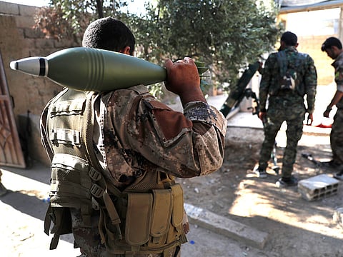 In this July 27, 2017 file photo, U.S.-backed Syrian Democratic Forces fighters prepare to fire a mortar shell, at one of the front lines, in Raqqa, northeast Syria.