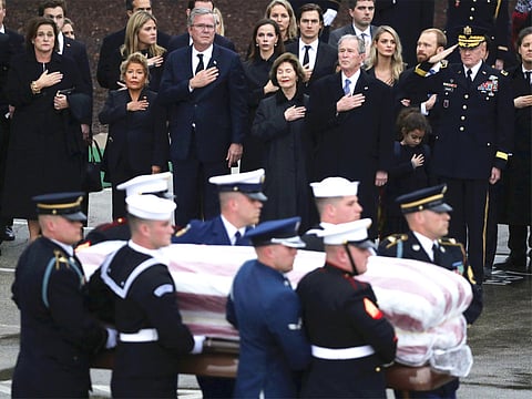 The flag-draped casket of former President George H.W. Bush is carried by a joint services military honor guard