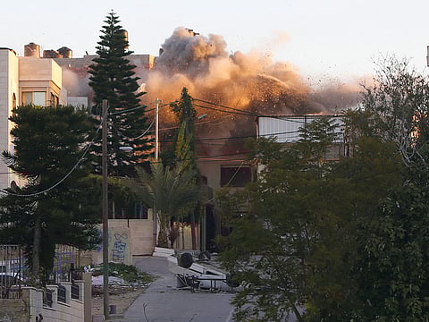 Smoke rises from a house belonging to a Palestinian accused of killing an Israeli soldier by dropping a slab from a roof during a raid last May