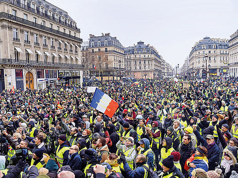 Protesters wearing yellow vests demonstrate in Paris yesterday against the rising cost of living. The movement originally started as a protest about planned fuel hikes but has morphed into a mass protest against President Emmanuel Macron’s policies.