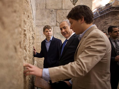 In this Jan. 22, 2013, file photo, Israeli Prime Minister Benjamin Netanyahu, center, prays with his sons Yair Netanyahu, left, and Avner Netanyahu in Occupied Jerusalem's old city
