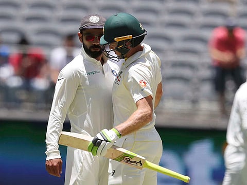 India's captain Virat Kohli (C) and Australia's captain Tim Paine react after Paine ran a single during play on day four of the second test match between Australia and India at Perth Stadium in Perth, Australia, December 17, 2018.