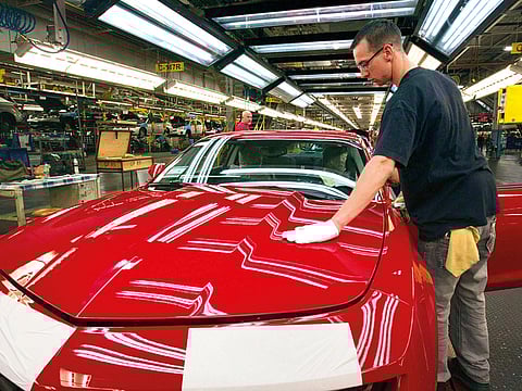 A worker checks the paint on a Camaro at the GM factory in Oshawa, Ontario, in June 2011.