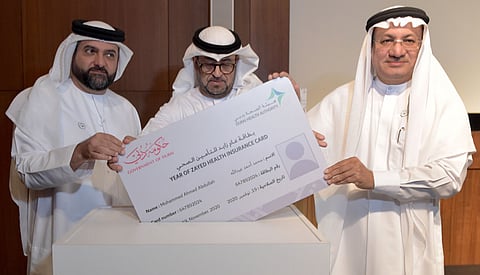 DHA unveils free insurance cards for 100 needy expatriates