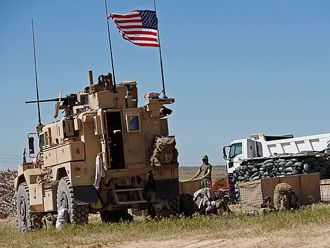 A U.S. soldier stands in a newly installed position near the front line between the U.S-backed Syrian Manbij Military Council and the Turkish-backed fighters, in Manbij, north Syria.