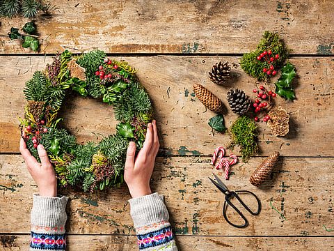 Overhead view of an arrangement of a Christmas wreath or garland being made.