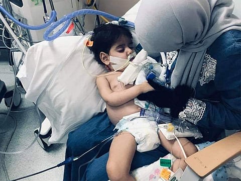 Shaima Swileh holding her 2-year-old son Abdullah at the hospital in Oakland