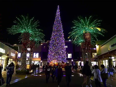 People shop for gifts a week before Christmas at an outlet mall in Commerce, California.