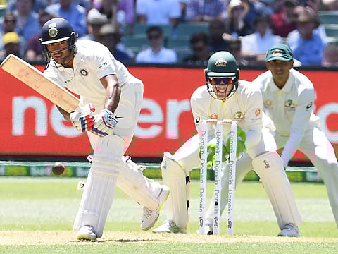 India's Mayank Agarwal (L) plays a shot as Australia's Tim Paine (C) and Usman Khawaja look on during day one of the third test match between Australia and India at the MCG in Melbourne, Australia, December 26, 2018.