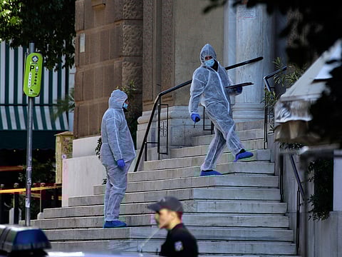 Greek forensic experts search at the scene after an explosion outside the Orthodox church of Agios Dionysios in the upscale Kolonaki area of Athens, Thursday, Dec. 27, 2018.