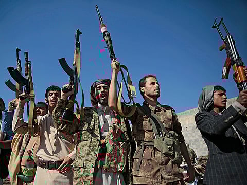 Tribesmen loyal to Houthi rebels hold up their weapons