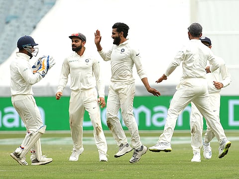 India's Ravindra Jadeja (C) celebrates with his teammates after dismissing Australia's captain Tim Paine on day four of the third test match between Australia and India at the MCG in Melbourne, Australia, December 29, 2018.