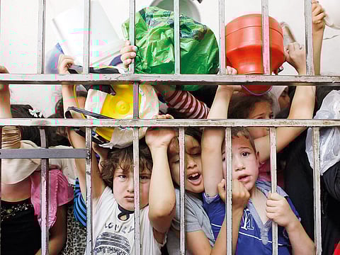 Palestinian children wait to receive food at a soup kitchen.
