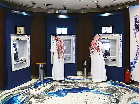 Customers use ATMs inside a bank in Saudi Arabia. Downward pressure on profitability and loan quality due to deteriorating operating conditions resulting from low oil prices and the impact of coronavirus (COVID-19) outbreak is likely to result in more credit rating downgrades of banks in the region, according to rating agencies.