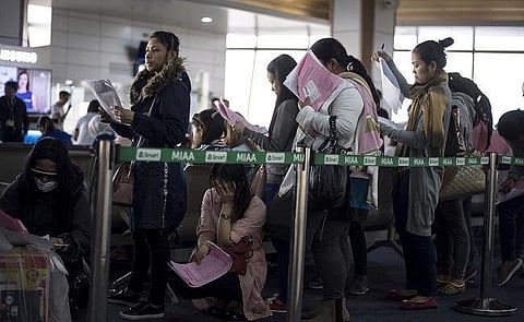 Overseas Filipino workers form a queue at the Manila international airport.