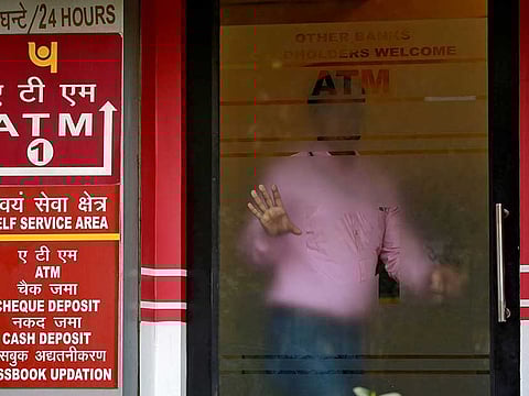 A man leaves an automated teller machine (ATM) facility of Punjab National Bank (PNB) in New Delhi, India.