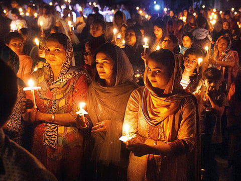 File photo: Pakistani Christian devotees holding candles while attending a Easter vigil mass at the Sacred Heart Church in Lahore on Sunday.