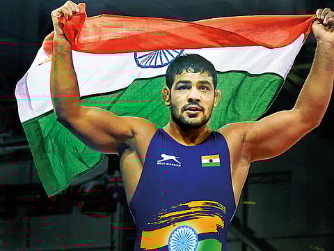 India's Sushil Kumar celebrates holding tricolour after winning a gold medal in the men's freestyle 74kg wrestling final bout against South Africans' Johannes Botha at the Commonwealth Games 2018 in Gold Coast, on Thursday.