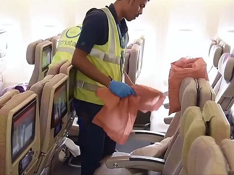 A worker cleans the seats in one of Emirates' passenger planes.