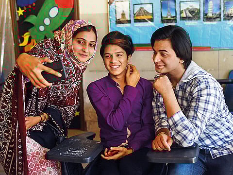 Pakistani teacher Eeman (left) takes selfies with students on the opening day of the first transgender school in Lahore in a file picture..