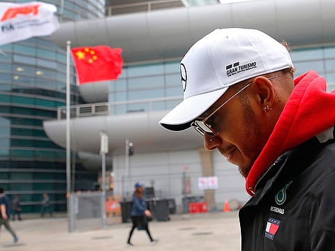 In this April 12, 2018 file photo, Mercedes driver Lewis Hamilton of Britain walks at the paddock of the Shanghai International Circuit ahead of the Chinese Formula One Grand Prix in Shanghai.