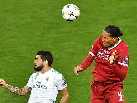 Liverpool's Virgil Van Dijk and Real Madrid's Isco vie for the ball